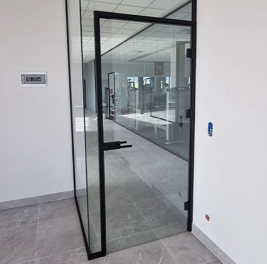 zabudowy i drzwi szklane z czarną framugą